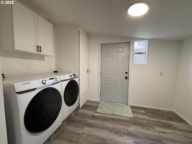 laundry area with cabinet space, baseboards, dark wood-type flooring, and washer and dryer