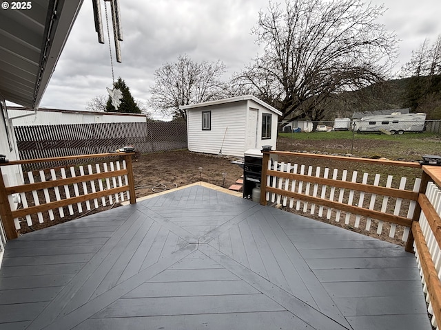 wooden deck featuring a fenced backyard and an outdoor structure