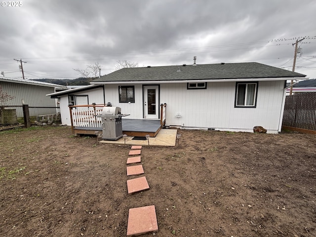 back of house featuring crawl space, roof with shingles, fence, and a wooden deck