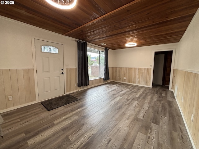 entryway featuring dark wood-type flooring, wood walls, wainscoting, and wood ceiling