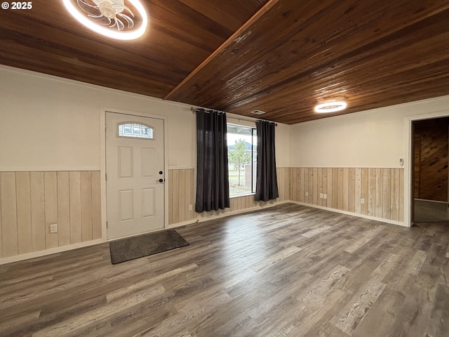 entrance foyer featuring a wainscoted wall, wooden ceiling, and wood finished floors