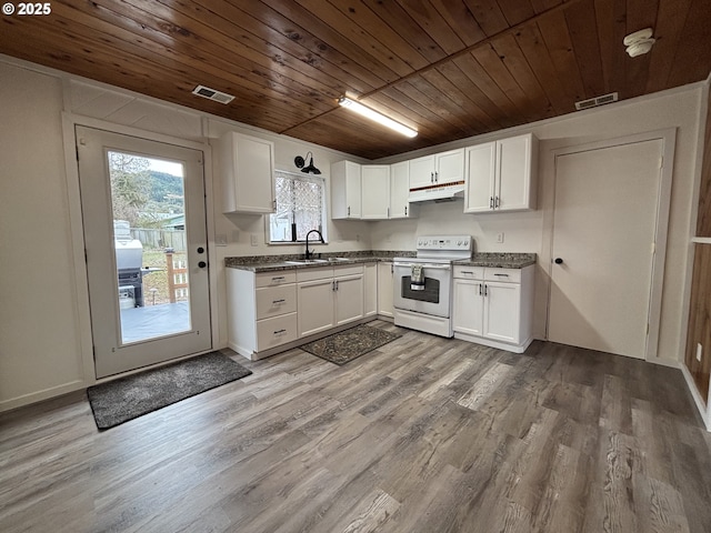 kitchen featuring under cabinet range hood, a sink, visible vents, white cabinets, and white range with electric stovetop