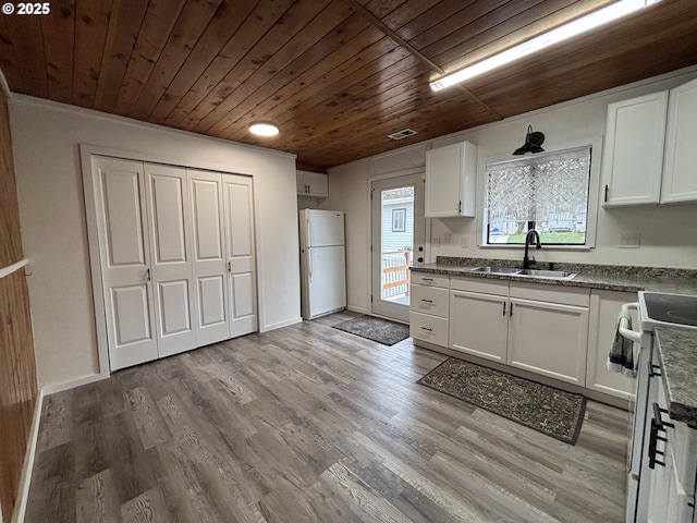 kitchen featuring white appliances, a sink, wood ceiling, and white cabinets