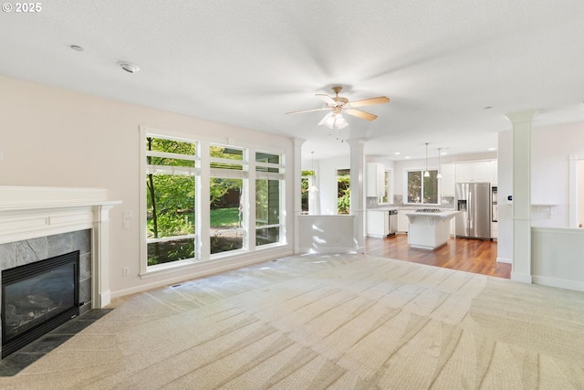 16273 Barlow Dr, Oregon City, OR 97045 - unfurnished living room with light carpet, a premium fireplace, a ceiling fan, decorative columns, and recessed lighting