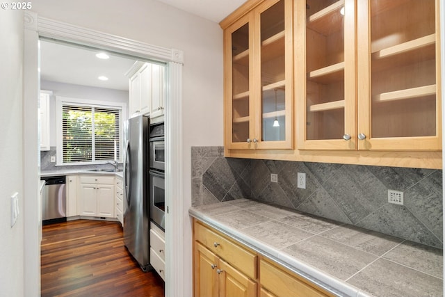 16273 Barlow Dr, Oregon City, OR 97045 - kitchen featuring appliances with stainless steel finishes, dark wood finished floors, glass insert cabinets, decorative backsplash, and recessed lighting
