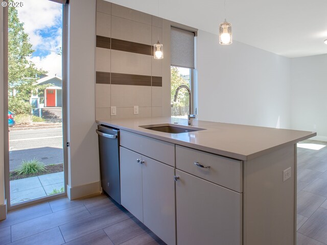 4984 NE 32nd Pl, Portland, OR 97211 - kitchen featuring dishwasher, a sink, a peninsula, light countertops, and pendant lighting