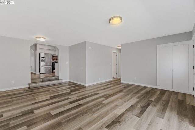 320 NE 117th Ave, Portland, OR 97220 - unfurnished living room with wood finished floors, baseboards, and arched walkways