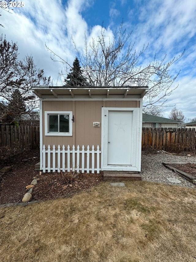 view of outbuilding featuring an outdoor structure and fence