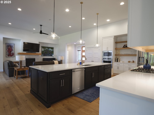 1703 SE 42nd Way, Brush Prairie, WA 98606 - kitchen with appliances with stainless steel finishes, open shelves, dark cabinets, a center island with sink, and white cabinetry