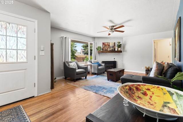 2408 N College St, Newberg, OR 97132 - living room with a ceiling fan, light wood-style floors, a fireplace, and baseboards