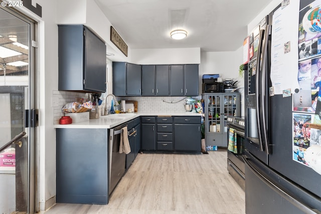 2408 N College St, Newberg, OR 97132 - kitchen with fridge with ice dispenser, a sink, light wood-style flooring, light countertops, and backsplash