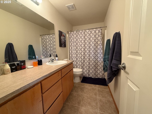 bathroom featuring vanity, toilet, and tile patterned flooring