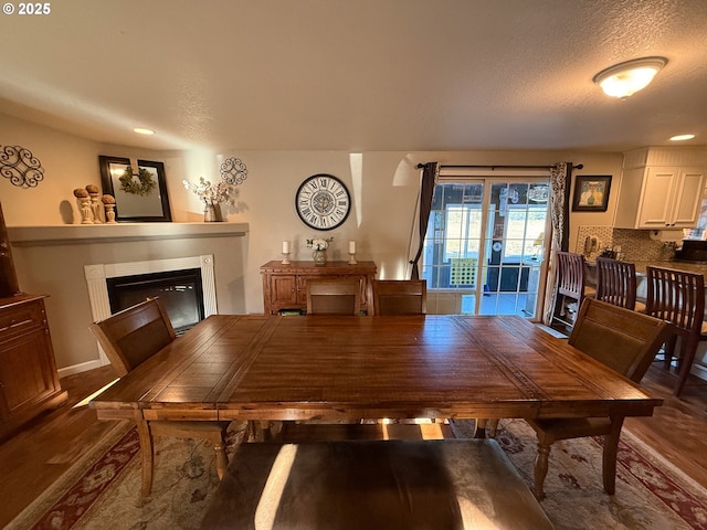 dining space featuring hardwood / wood-style flooring and a textured ceiling