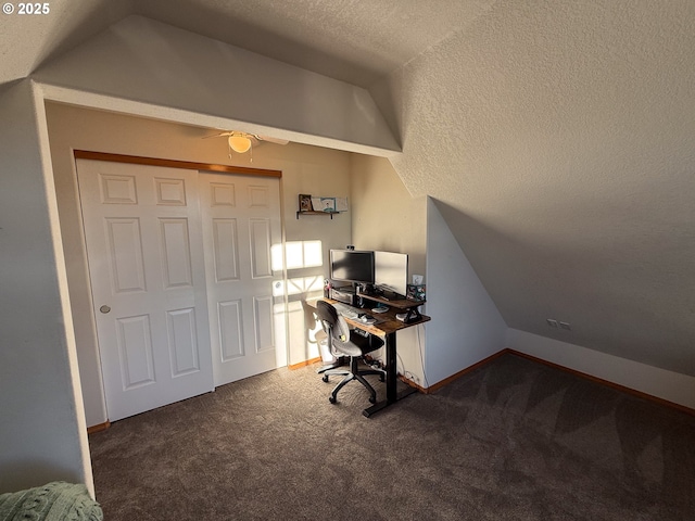 carpeted office space featuring ceiling fan, lofted ceiling, and a textured ceiling