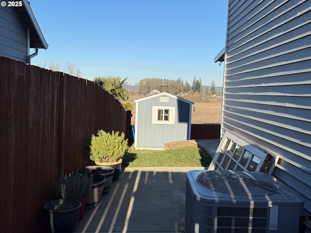 view of patio / terrace featuring central air condition unit and a shed