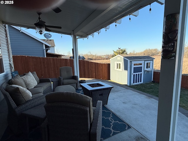 view of patio featuring an outdoor living space with a fire pit, ceiling fan, and a shed