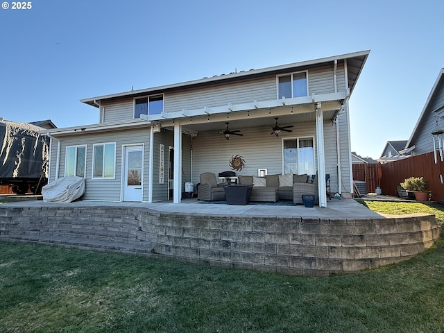 rear view of house featuring a patio area, outdoor lounge area, ceiling fan, and a lawn