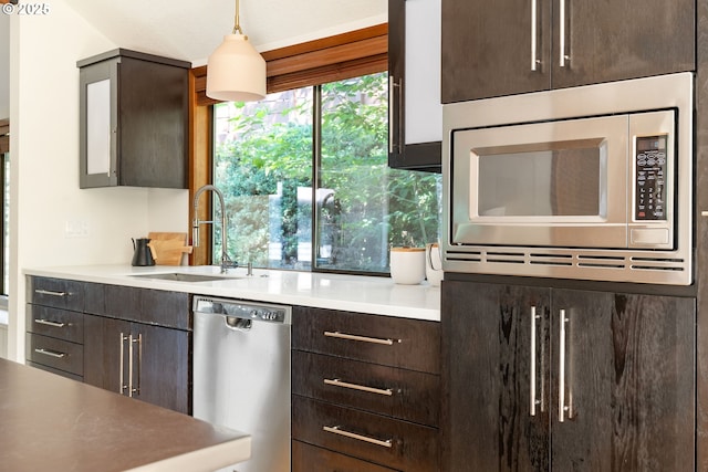 511 SW Colony Dr, Portland, OR 97219 - kitchen with appliances with stainless steel finishes, dark brown cabinetry, light countertops, and pendant lighting