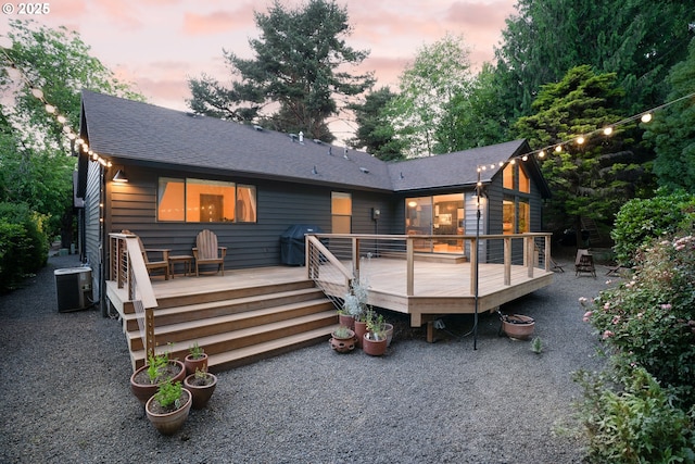511 SW Colony Dr, Portland, OR 97219 - back of house at dusk with roof with shingles and a deck