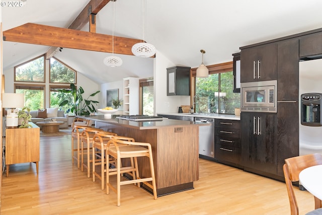 511 SW Colony Dr, Portland, OR 97219 - kitchen featuring appliances with stainless steel finishes, light wood-type flooring, a breakfast bar, a center island, and open floor plan
