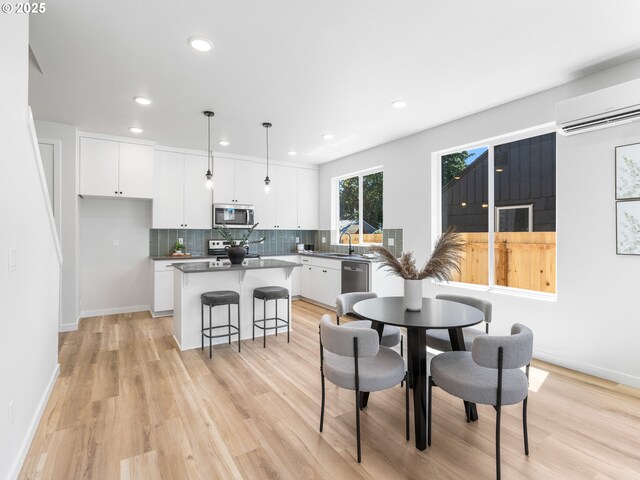 7244 SE 78th Ave Unit 2, Portland, OR 97206 - dining space with a wall mounted air conditioner, sink, and light hardwood / wood-style flooring