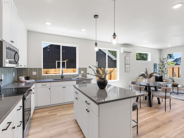 7244 SE 78th Ave Unit 2, Portland, OR 97206 - kitchen with a wall mounted air conditioner, appliances with stainless steel finishes, tasteful backsplash, sink, and white cabinets