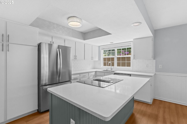 21689 SW Klickitat Ct, Tualatin, OR 97062 - kitchen with freestanding refrigerator, a sink, black electric stovetop, light wood-type flooring, and light countertops