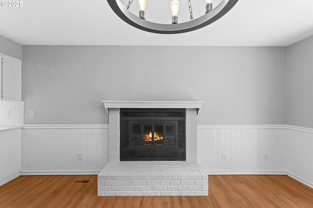 21689 SW Klickitat Ct, Tualatin, OR 97062 - detailed view of wood finished floors, wainscoting, and a fireplace