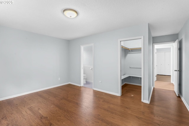 21689 SW Klickitat Ct, Tualatin, OR 97062 - unfurnished bedroom with dark wood finished floors, baseboards, a closet, and a spacious closet