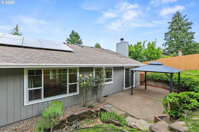 21689 SW Klickitat Ct, Tualatin, OR 97062 - rear view of property with a gazebo, solar panels, a patio, a chimney, and roof with shingles