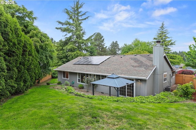21689 SW Klickitat Ct, Tualatin, OR 97062 - rear view of house with solar panels, a chimney, and roof with shingles