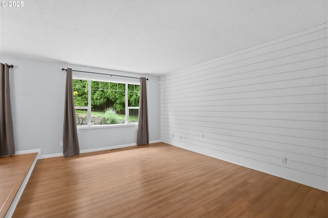21689 SW Klickitat Ct, Tualatin, OR 97062 - empty room with wood finished floors, a textured ceiling, and baseboards