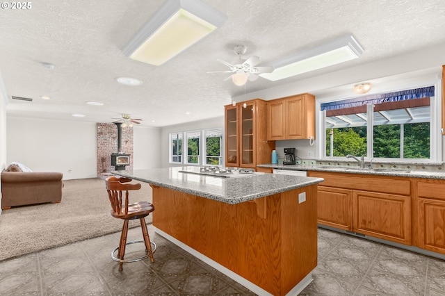 18183 SE Richey Rd, Gresham, OR 97080 - kitchen with a textured ceiling, a wood stove, a center island, a ceiling fan, and open floor plan