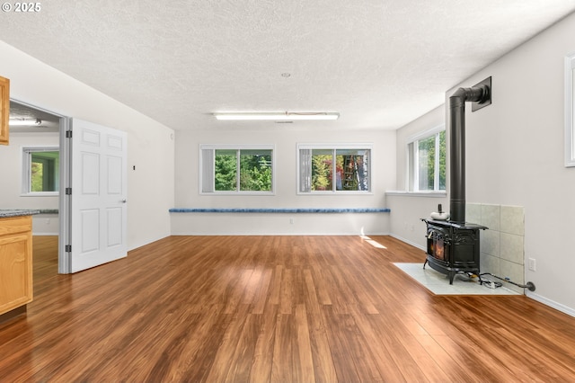 18183 SE Richey Rd, Gresham, OR 97080 - unfurnished living room featuring wood finished floors, a wood stove, and a textured ceiling
