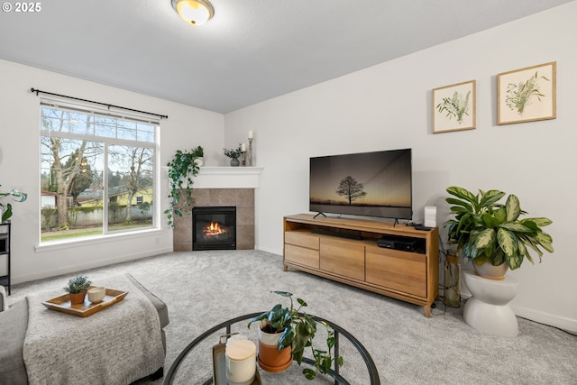 carpeted living room with a tiled fireplace