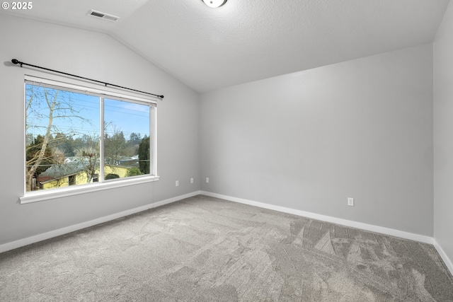 unfurnished room featuring lofted ceiling, a textured ceiling, and carpet flooring