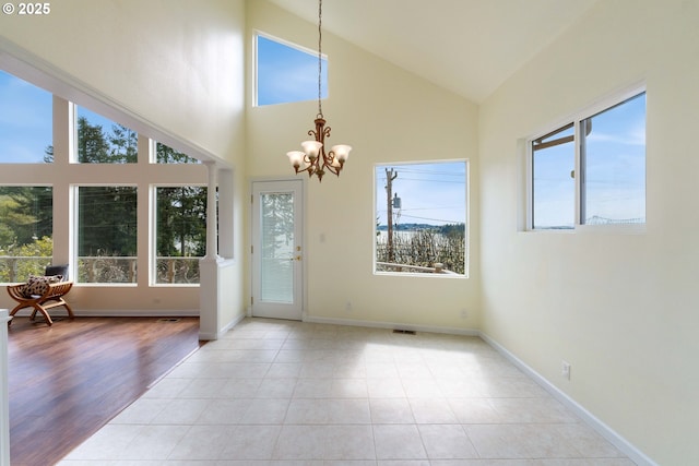 66599 Quail Rd, North Bend, OR 97459 - doorway featuring a chandelier, high vaulted ceiling, baseboards, and light tile patterned flooring