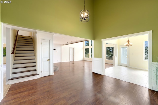 66599 Quail Rd, North Bend, OR 97459 - unfurnished living room with a chandelier, a high ceiling, stairs, and dark wood finished floors