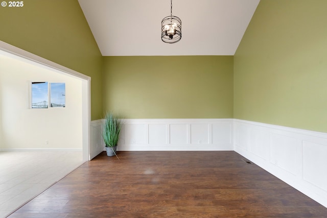 66599 Quail Rd, North Bend, OR 97459 - empty room featuring lofted ceiling, a wainscoted wall, dark wood finished floors, and a chandelier