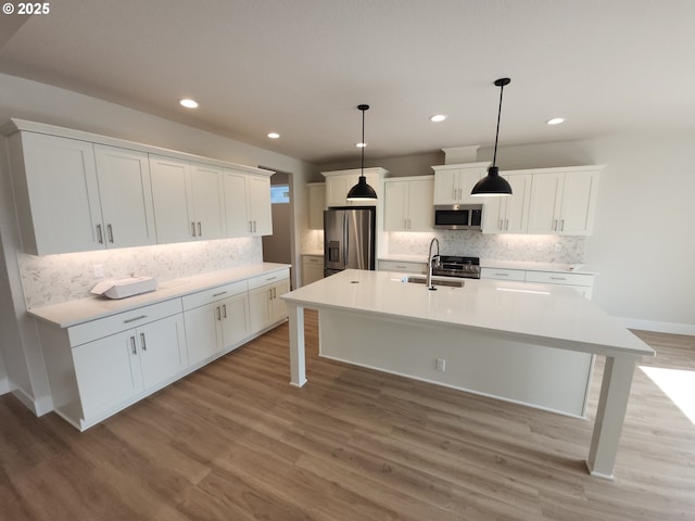 5602 N 93rd Ave Unit Lt205, Camas, WA 98607 - kitchen featuring appliances with stainless steel finishes, decorative backsplash, white cabinets, an island with sink, and recessed lighting
