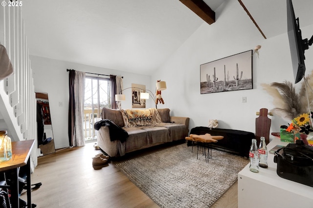 living area with vaulted ceiling with beams and light wood finished floors