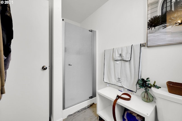 bathroom featuring a stall shower and toilet