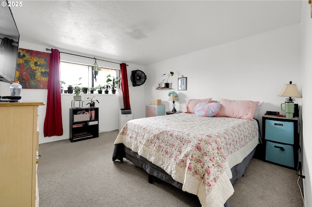 bedroom featuring light carpet and a textured ceiling