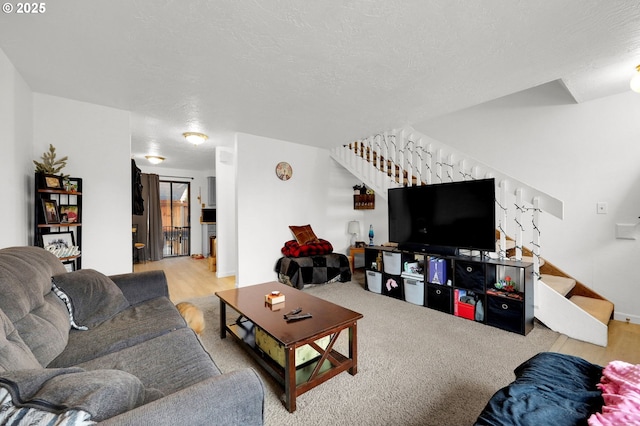 living room with a textured ceiling and stairway