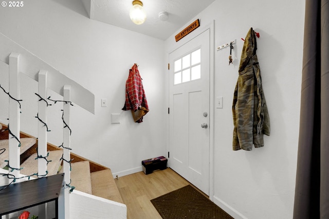 entryway featuring stairs, light wood finished floors, and baseboards