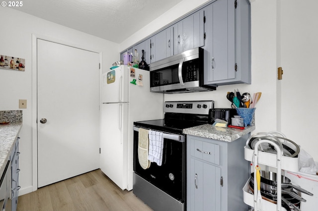 kitchen featuring light wood-style floors, appliances with stainless steel finishes, and gray cabinetry