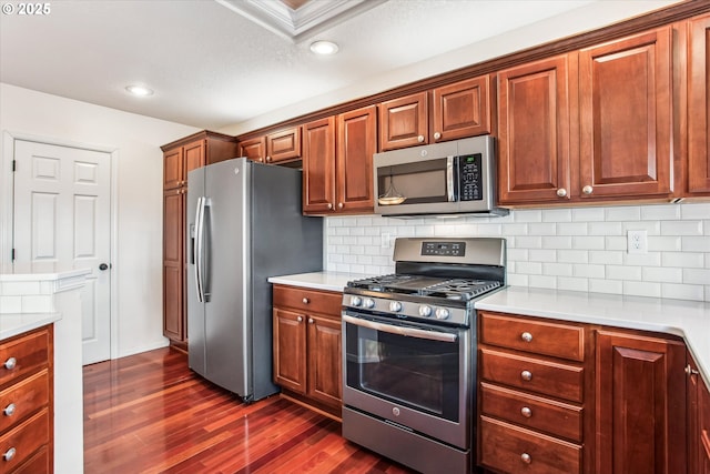 kitchen with dark wood-type flooring, appliances with stainless steel finishes, and decorative backsplash