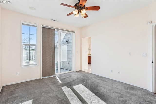 spare room with dark carpet and ceiling fan