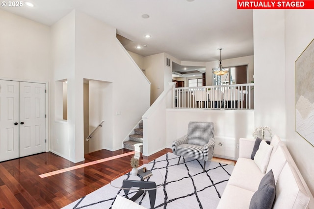 living room with wood-type flooring and a towering ceiling