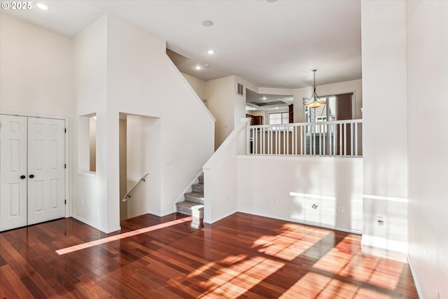 foyer with hardwood / wood-style flooring and a towering ceiling